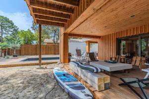 a large wooden house with two kayaks on a patio at Villa 10 pers à Carreyre, piscine chauffée, clim in Lacanau