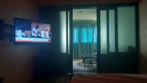 Zimmer mit einem Flachbild-TV an der Wand in der Unterkunft La gare agdal in Rabat