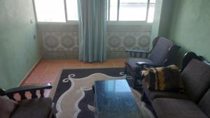 ein Wohnzimmer mit Sofa, Stühlen und einem Tisch in der Unterkunft La gare agdal in Rabat