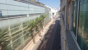 eine leere Straße mit Palmen vor einem Gebäude in der Unterkunft La gare agdal in Rabat