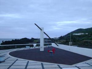 a child in a red coat is playing with a pole at Casa da Baía da Manhenha in Manhenha