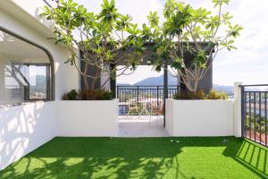 a room with a balcony with green grass and plants at Fantasea Condo Kamala A209 2BDRM by Phuket Sabay Rent in Kamala Beach +36 photos