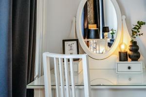 a white chair in front of a mirror at BlueBell Hotel in Bratislava