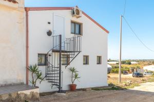 una casa bianca con una scala a chiocciola di 3 Twins Suite Portopalo a Portopalo