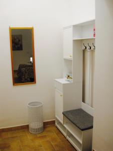 a bathroom with white cabinets and a mirror and a bench at Alloggio Turistico Corso Italia 74 Viterbo in Viterbo