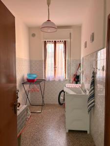 a bathroom with a sink and a table and a window at La Casa di Nonna Maria in Treglio