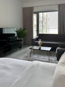 un salon avec un lit, un canapé et une table dans l'établissement Bright & Modern Studio Masdar City, Abu Dhabi, à Abu Dhabi