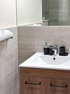une salle de bains avec un lavabo blanc et un miroir dans l'établissement Bright & Modern Studio Masdar City, Abu Dhabi, à Abu Dhabi 22 autres photos