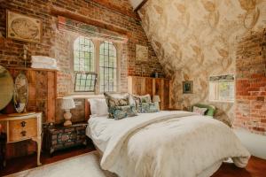 a bedroom with a bed and a brick wall at Salmestone Grange in Margate