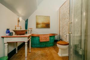 a bathroom with a tub and a toilet and a sink at Salmestone Grange in Margate