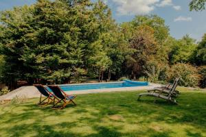 three chairs sitting in the grass near a swimming pool at Salmestone Grange in Margate +31 photos
