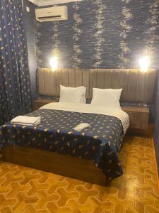 una camera con un letto con una parete a motivi blu di Hôtel Jeanne d'Arc Central a Baku Altre 11 foto