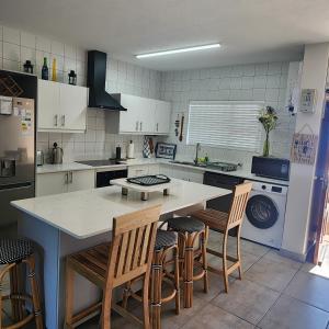 a kitchen with a counter and some chairs in it at Dolfyn201 La Mer in Hartenbos