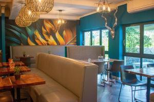 a dining room with a couch in a restaurant at Silver Forest Boutique Hotel, Spa, Restaurant & Bar in Somerset West