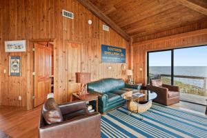 a living room with a couch and chairs and the ocean at Rustic Retreat in Ocean Springs