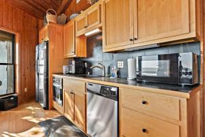 a kitchen with wooden cabinets and a stainless steel dishwasher at Rustic Retreat in Ocean Springs