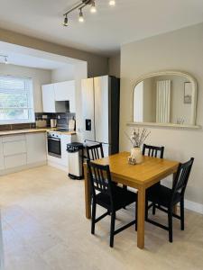 a kitchen and dining room with a wooden table and chairs at Ruby's Home in Wistaston