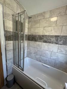 a bathroom with a tub and a glass shower at Ruby's Home in Wistaston +15 photos