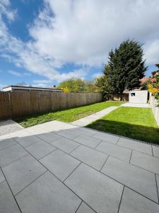 a backyard with a concrete patio and a fence at Ruby's Home in Wistaston