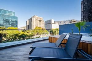 a patio with two chairs and a table on a balcony at 1007 Zeeland - Top Floor Stylish Studio Near CTICC in Cape Town