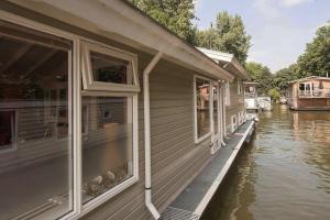 a house on the water next to a river at Bed and breakfast private accommodation at Amsterdam Houseboat in Amsterdam