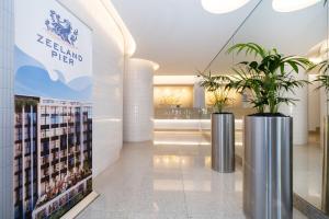 a lobby with two potted plants in a building at 1007 Zeeland - Top Floor Stylish Studio Near CTICC in Cape Town +32 photos