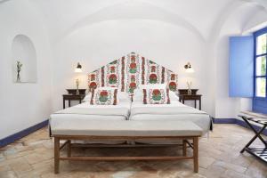 a bedroom with a large bed with a head board at Monasterio de San Francisco in Palma del Río +92 photos