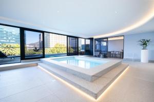 a large swimming pool in a building with windows at 1007 Zeeland - Top Floor Stylish Studio Near CTICC in Cape Town