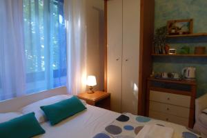 een slaapkamer met een bed met blauwe kussens en een raam bij B&B Al Santo in Padua