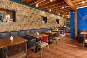 een eetkamer met tafels en stoelen en een muur bedekt met bloemen bij Central Heritage Hotel in Split