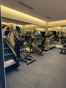 a gym with several treadmills and elliptical machines at فندق حياة تاون حقل in Ḩaql