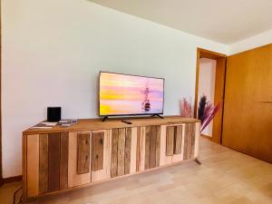ein Flachbildfernseher auf einem hölzernen Entertainment-Center in der Unterkunft Chaletwohnung Thilo in Lenk im Simmental