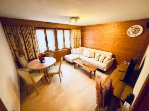 ein Wohnzimmer mit Sofa und Tisch in der Unterkunft Chaletwohnung Thilo in Lenk im Simmental