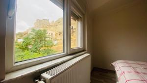 een slaapkamer met een raam met uitzicht op een kasteel bij Peribacası Manzaralı Modern Daire 2 in Urgup