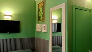 Habitación verde con espejo y TV en BOBOTEL RESIDENZA Center, Pop Art Design, 24h Remote Check in, en Florencia