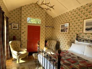 a bedroom with a bed and a red door at The Gatehouse in Trimingham