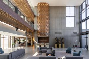 a lobby with couches and chairs in a building at Balaton Park Hotel in Balatonfőkajár