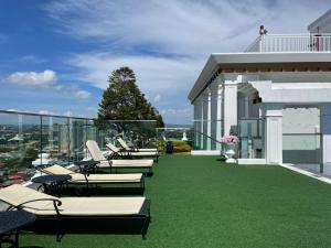 une rangée de chaises longues sur un balcon avec de l'herbe verte dans l'établissement The Empire Tower Pattaya, à Jomtien Beach