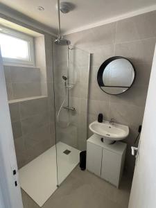 a bathroom with a shower and a sink and a mirror at Maison refaite à neuf avec jacuzzi - LE HOMARD 13 in Perros-Guirec