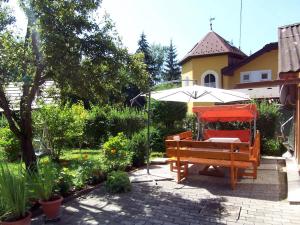 a bench and an umbrella in a garden at Ferienhaus an der Waldquelle in Pörtschach am Wörthersee +10 photos