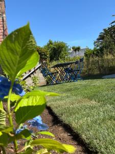 a picnic table and chairs in a yard at Maison refaite à neuf avec jacuzzi - LE HOMARD 13 in Perros-Guirec