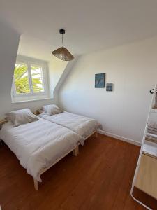a bedroom with two beds and a window at Maison refaite à neuf avec jacuzzi - LE HOMARD 13 in Perros-Guirec