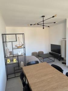 a living room with a table and a television at Maison refaite à neuf avec jacuzzi - LE HOMARD 13 in Perros-Guirec +24 photos