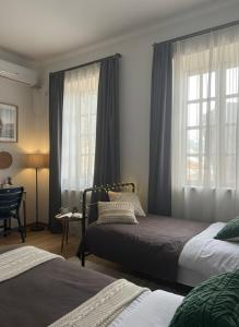 Un dormitorio con dos camas y una ventana. en Georgian House Old Town, en Tiflis