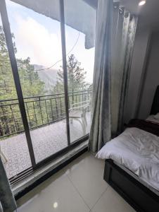 a bedroom with a bed and a large window at Galiyat Hilton apartment and hotel in Ayubia +16 photos