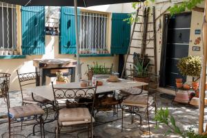 a patio with a table and chairs and an umbrella at site paradis rue colibri in Avignon