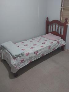 Una cama pequeña en una habitación con colcha. en Casa Aconchegante, en Nova Odessa