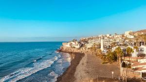 an aerial view of a beach with houses and the ocean at La Orilla in San Agustin