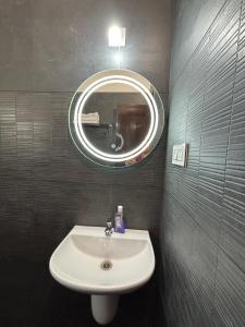 un baño con lavabo y espejo en Sooru The Beach Stay, en Padubidri