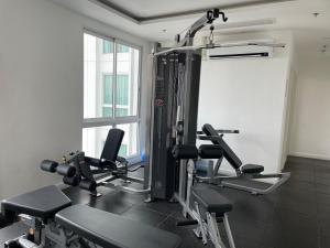 une salle de sport avec plusieurs tapis de course devant une fenêtre dans l'établissement The Empire Tower Pattaya, à Jomtien Beach